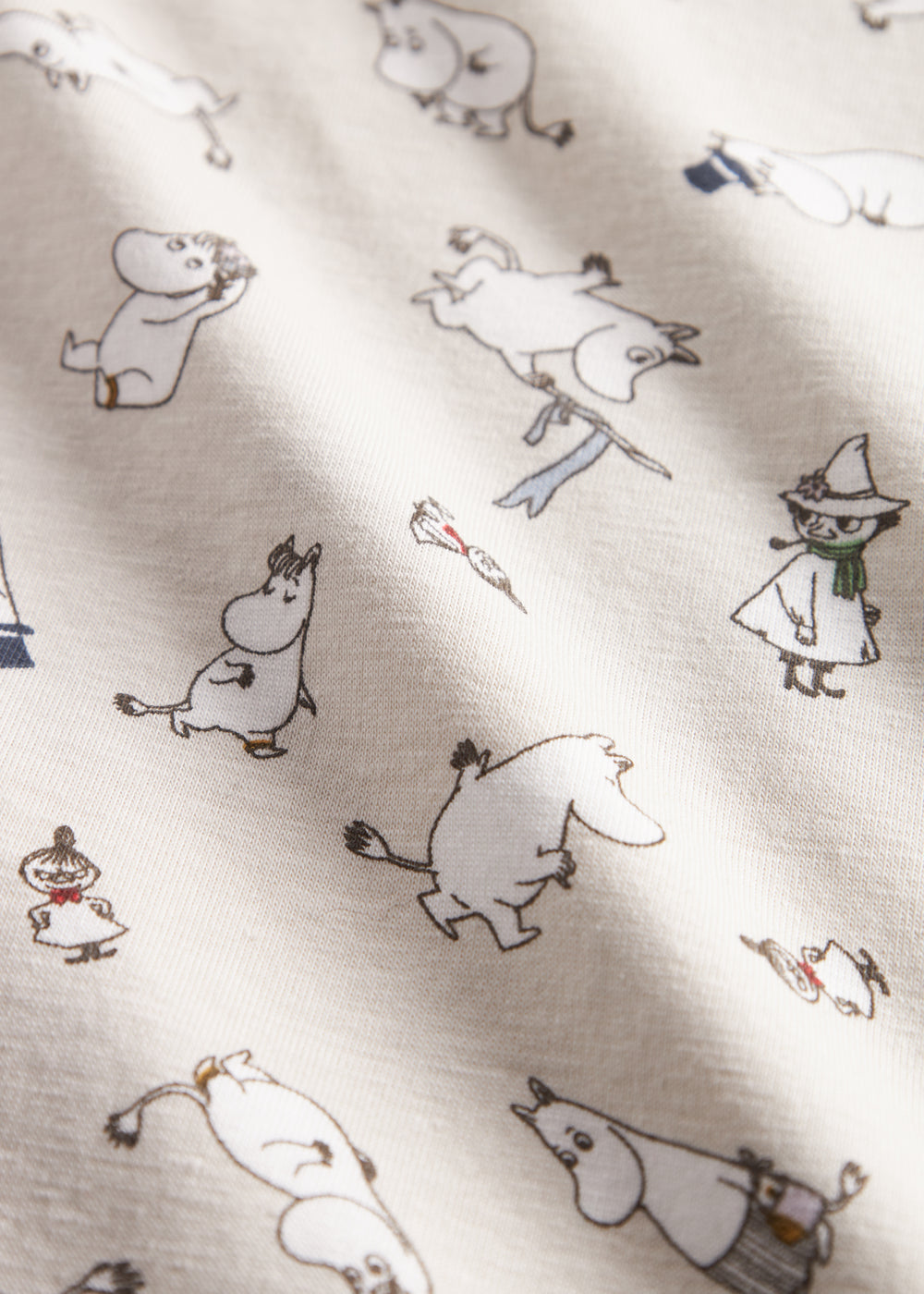 Baby tæppe med Moomin-print i lyse farver.