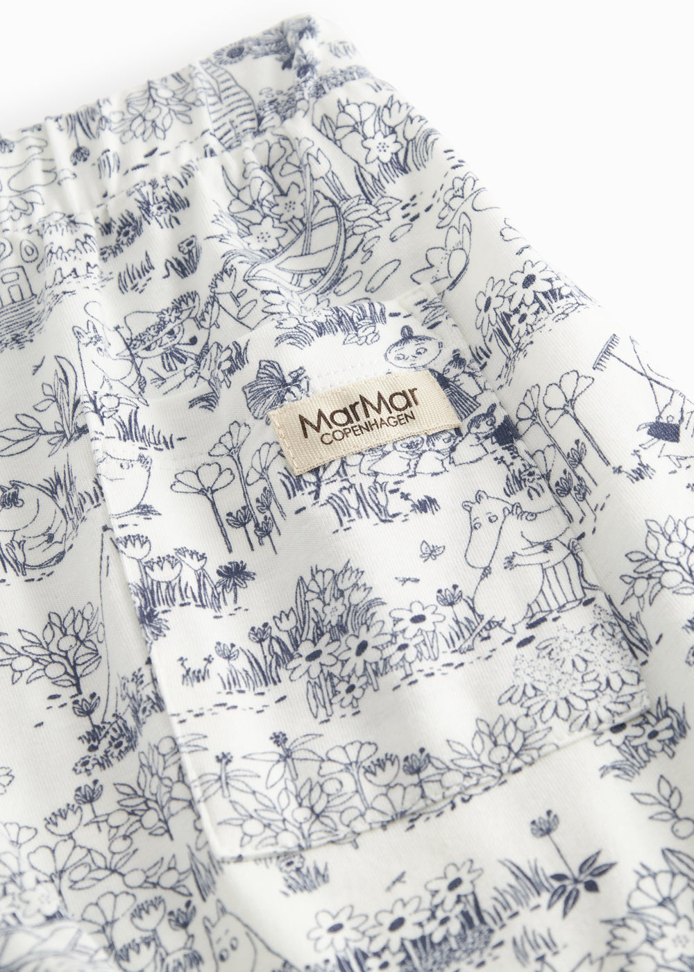 Shorts for children with a fine Moomin print, wide elastic, and ties at the waist.