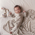 Baby ligger på baby tæppe med Moomin-print