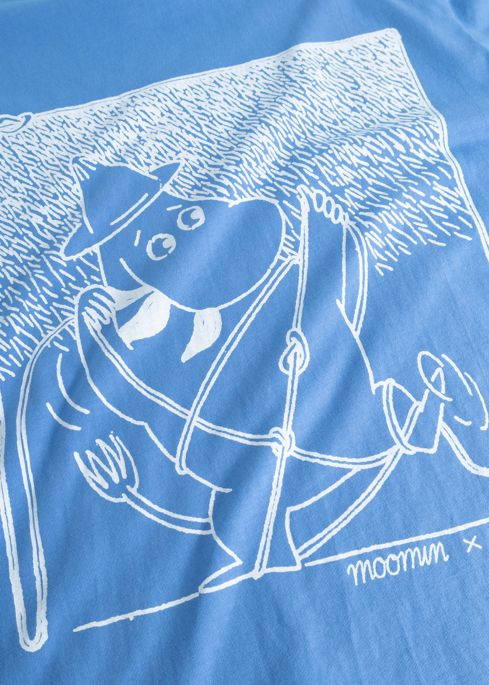 Blue blouse with white Moomin scout motif in front.