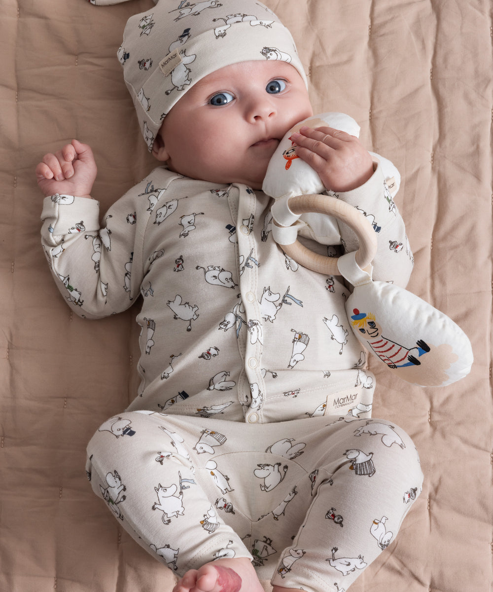 Baby iført babyhue med Moomin-print og matchende tøj