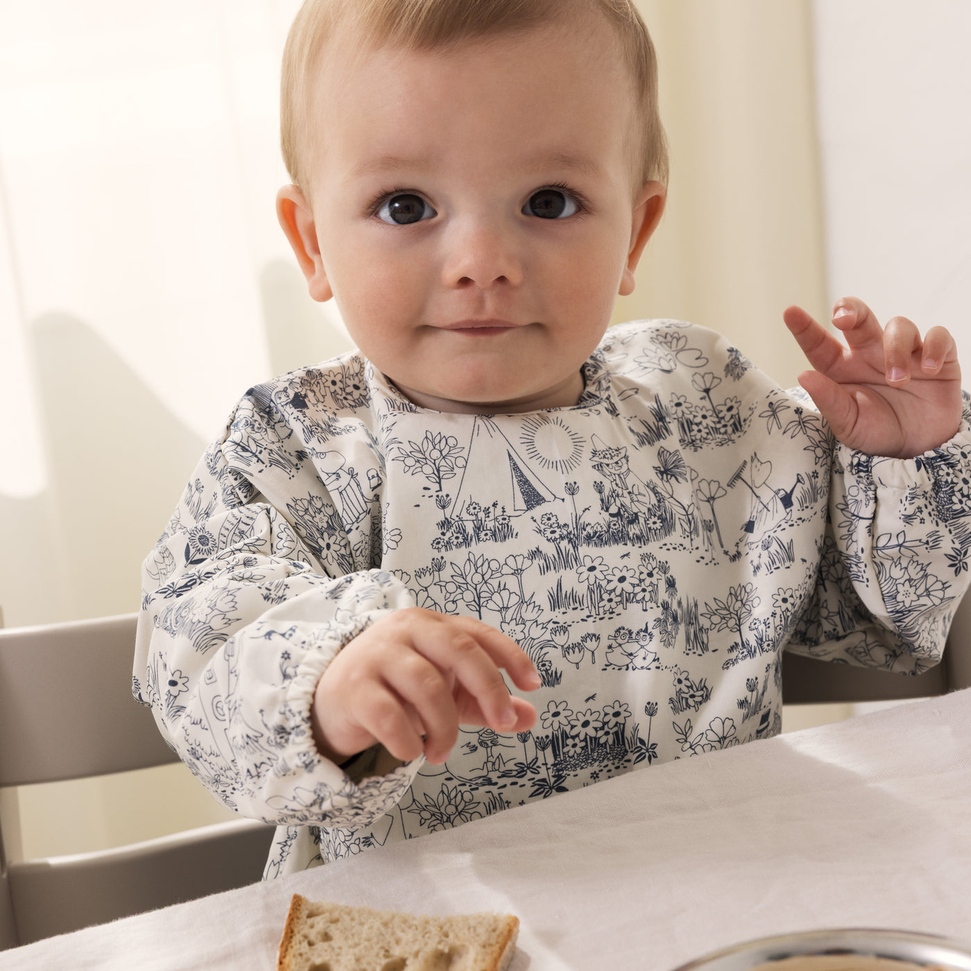 Baby med spiseforklæde i mumi print