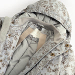 Jacket with high collar and pattern, visible pressure buttons and inner edge.
