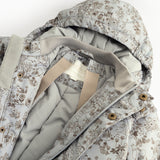 Jacket with high collar and pattern, visible pressure buttons and inner edge.