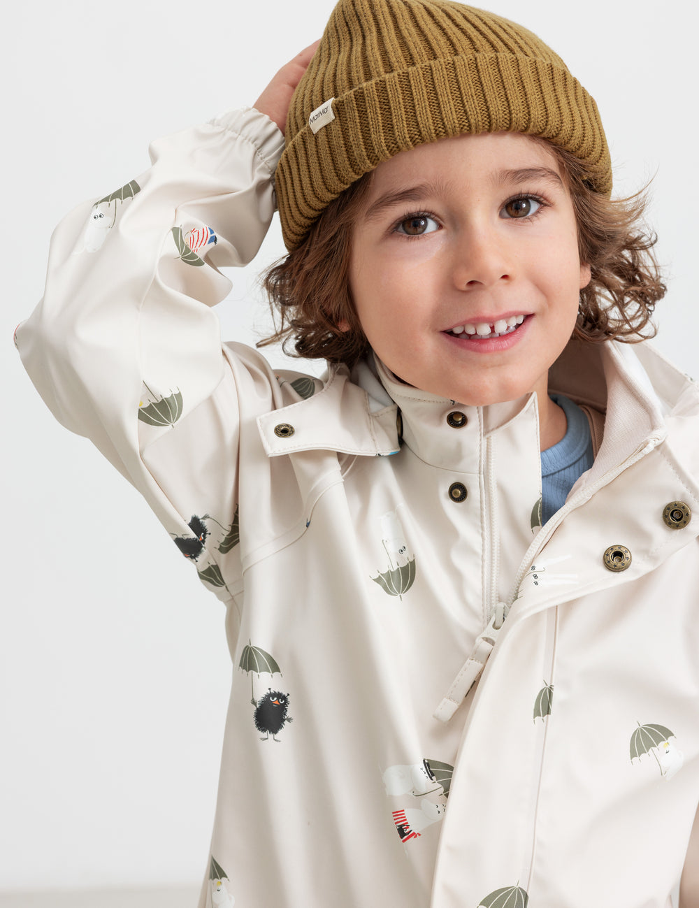 Child wearing a brown knitted hat and indoor raincoat.