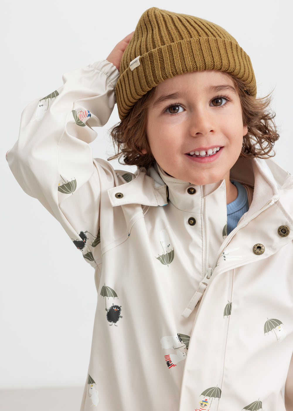 Child wearing a brown knitted hat and indoor raincoat.