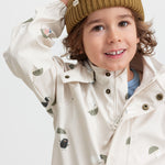 Child wearing a brown knitted hat and indoor raincoat.