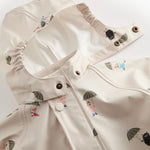Beige baby raincoat with Moomin print, hat, and booties.