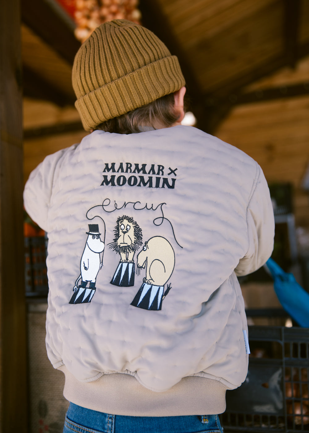 Children's set includes a green jacket with Moomin print and a brown hat.