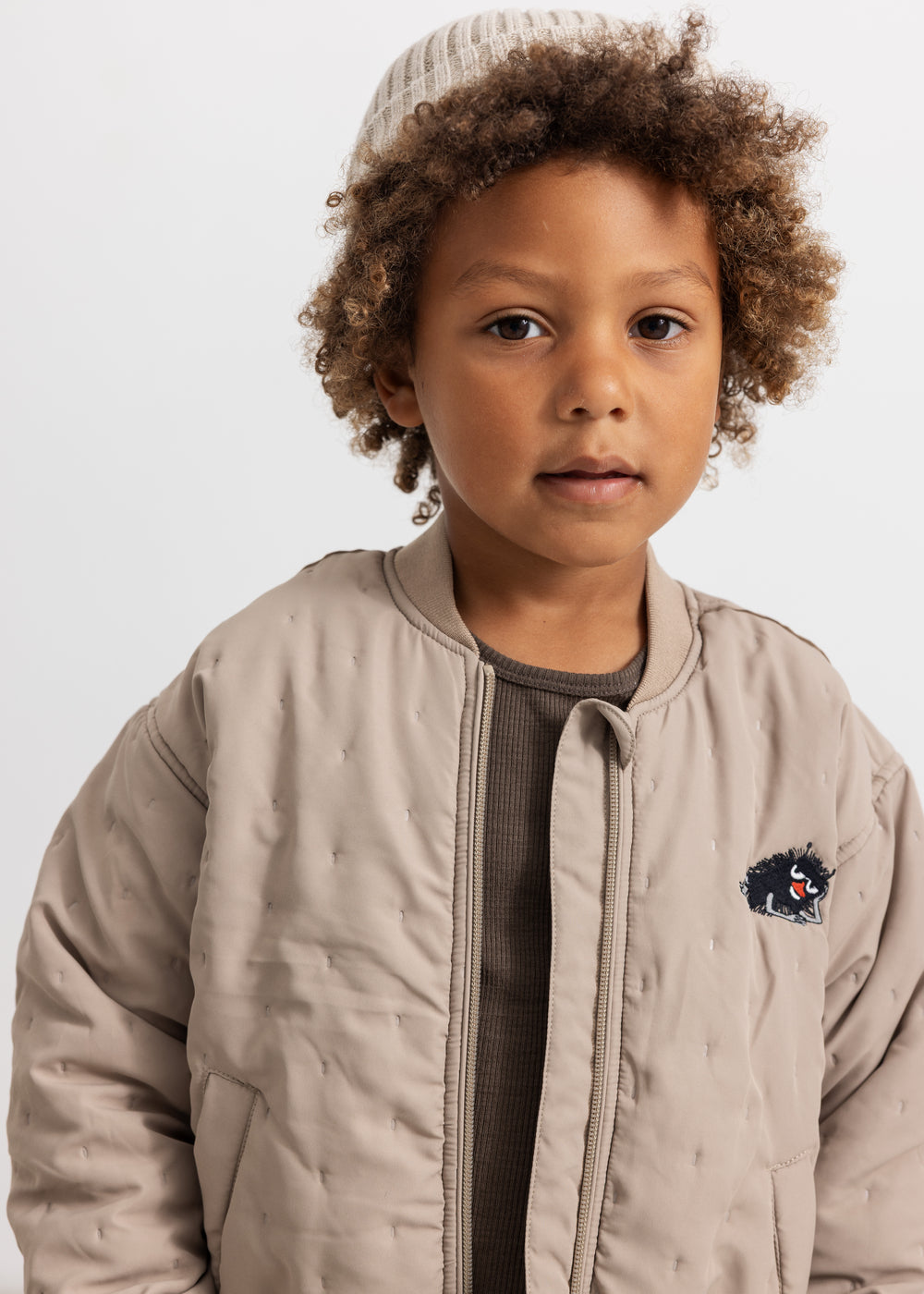 Light gray insulated jacket for children with zipper, hood collar, and small chest patch.