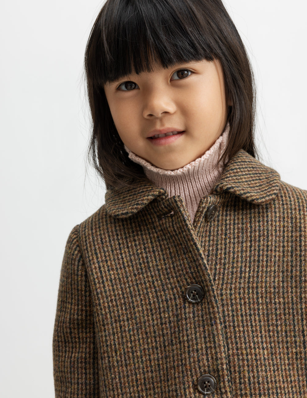 Barn i brun ternet uldfrakke med krave