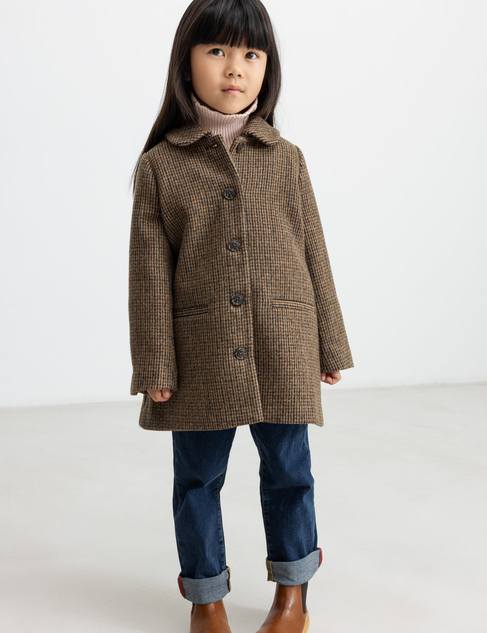 Pige iført brun ternet uldfrakke