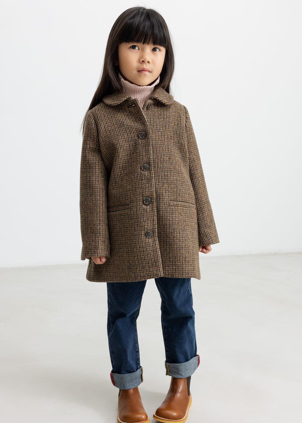 Pige iført brun ternet uldfrakke