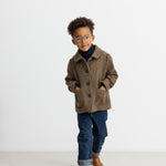 Dreng iført brun ternet jakke med krave