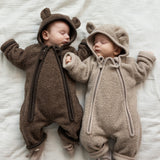 To babyer iført teddyheldragter, den ene i lys beige og den anden i brun