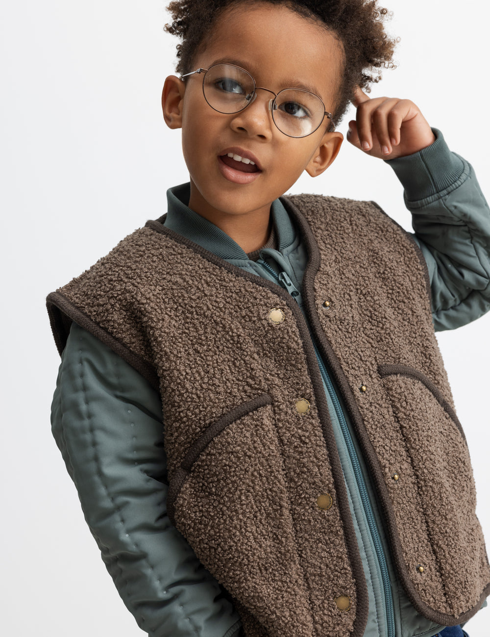 Barn iført brun teddyvest over jakke