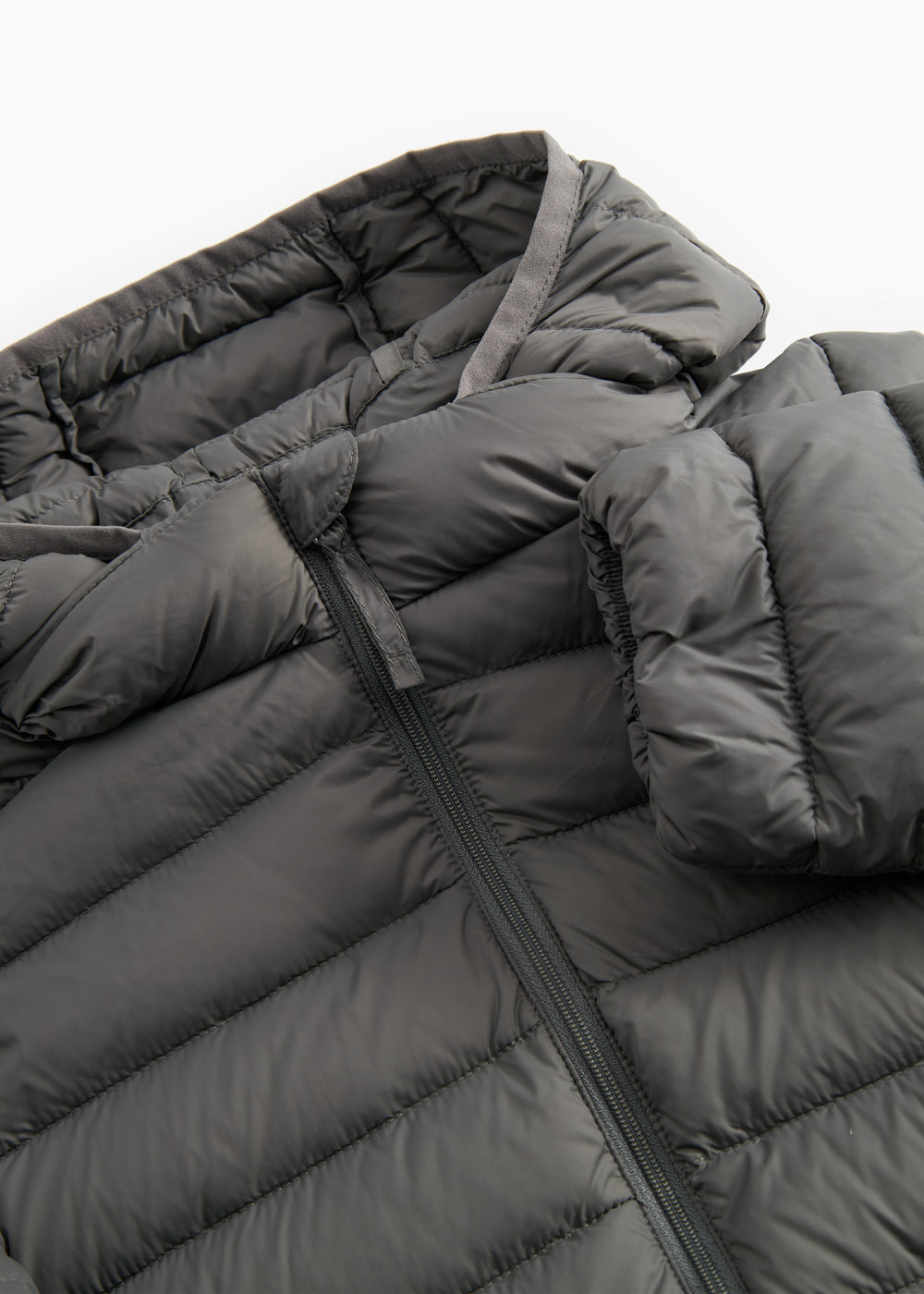 Detalje af lynlås på mørkegrå vatteret jakke