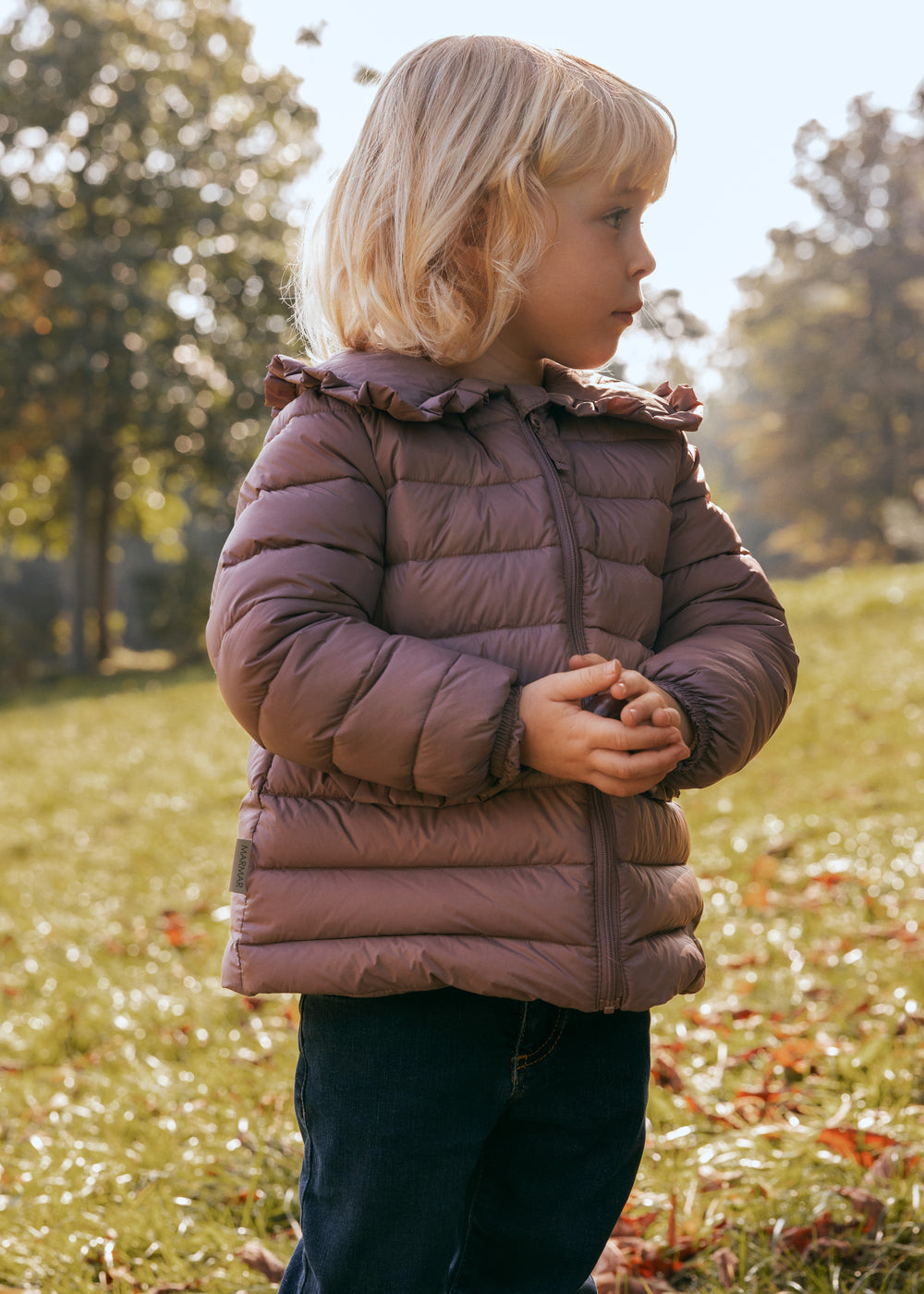 Børn leger i efterårsblade iført rosa vatteret jakke med flæsekrave
