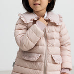 Pige iført lyserød vatteret jakke med flæsekrave