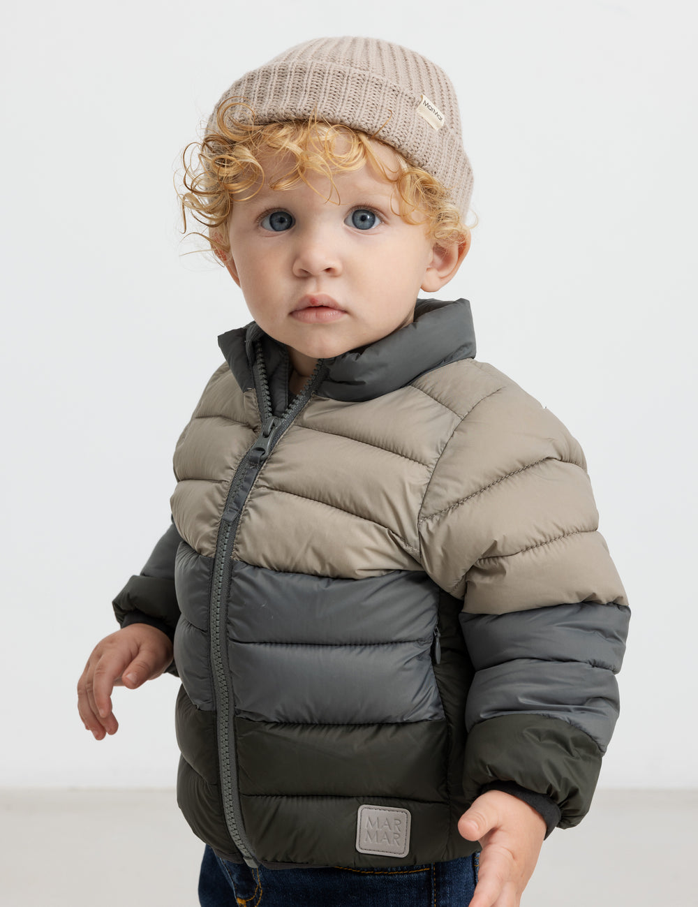 Barn iført beige strikkedjak todeltelteltke