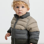 Dreng med beige hue iført vatteret jakke i grønne og beige toner