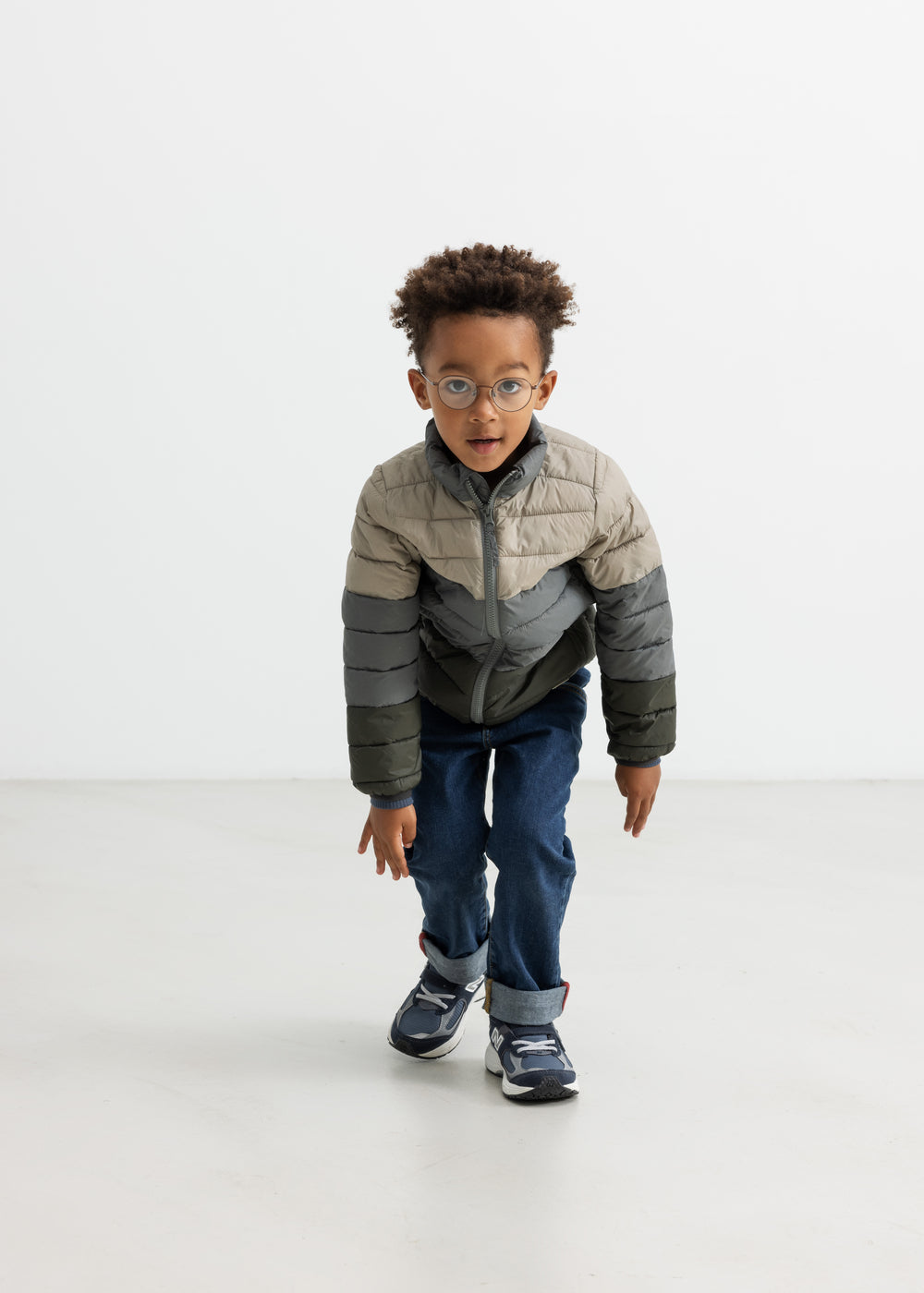 Dreng iført vatteret jakke i beige og grønne nuancer