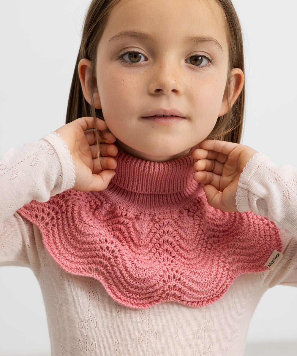 Pige med lyserød bluse i merinould og mørkrosa halsedisse