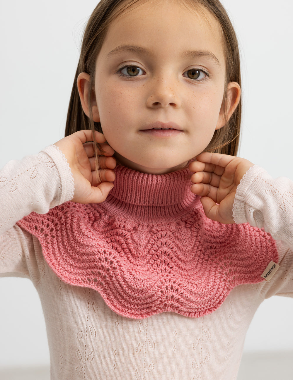 Girl with a red blouse in merino and a dark pink scarf.