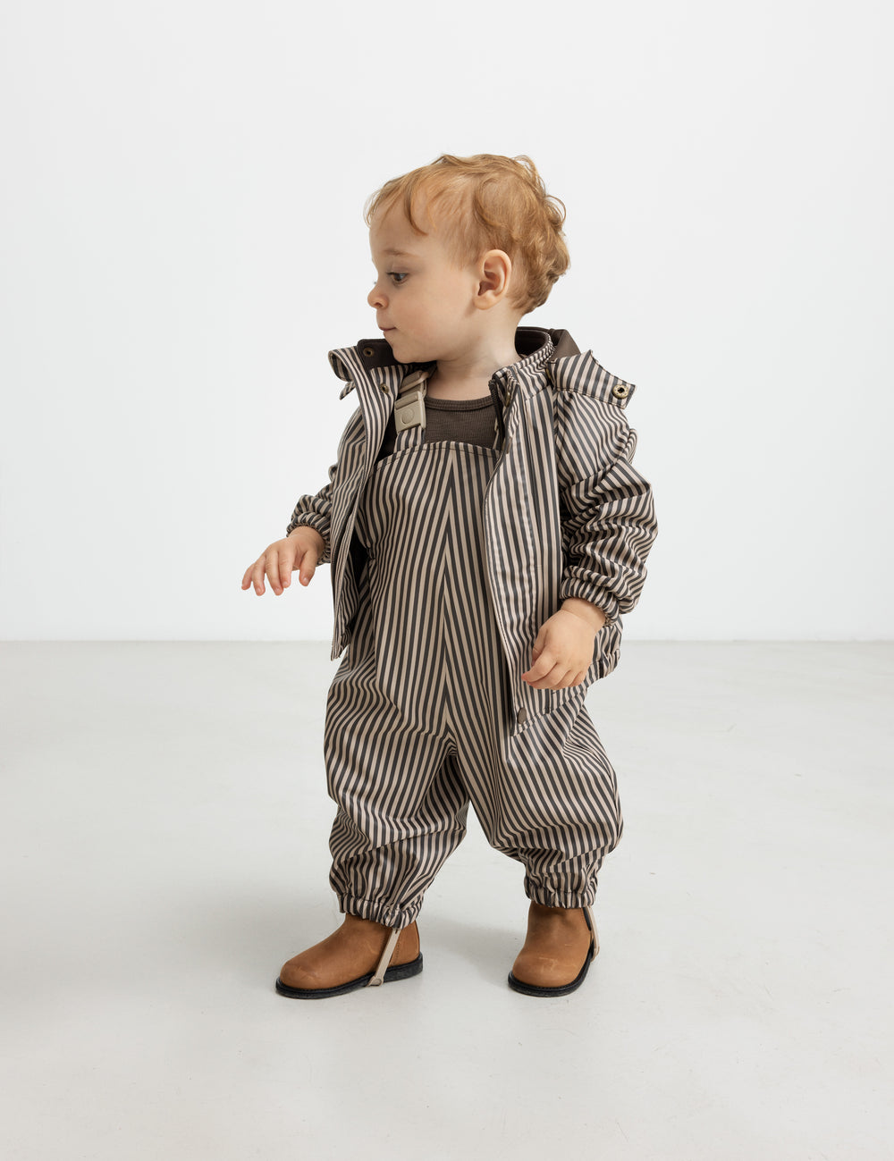 Baby regnsæt med brune striber og hætte, står op