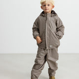 Børn iført brunt stribet regnsæt med hætte