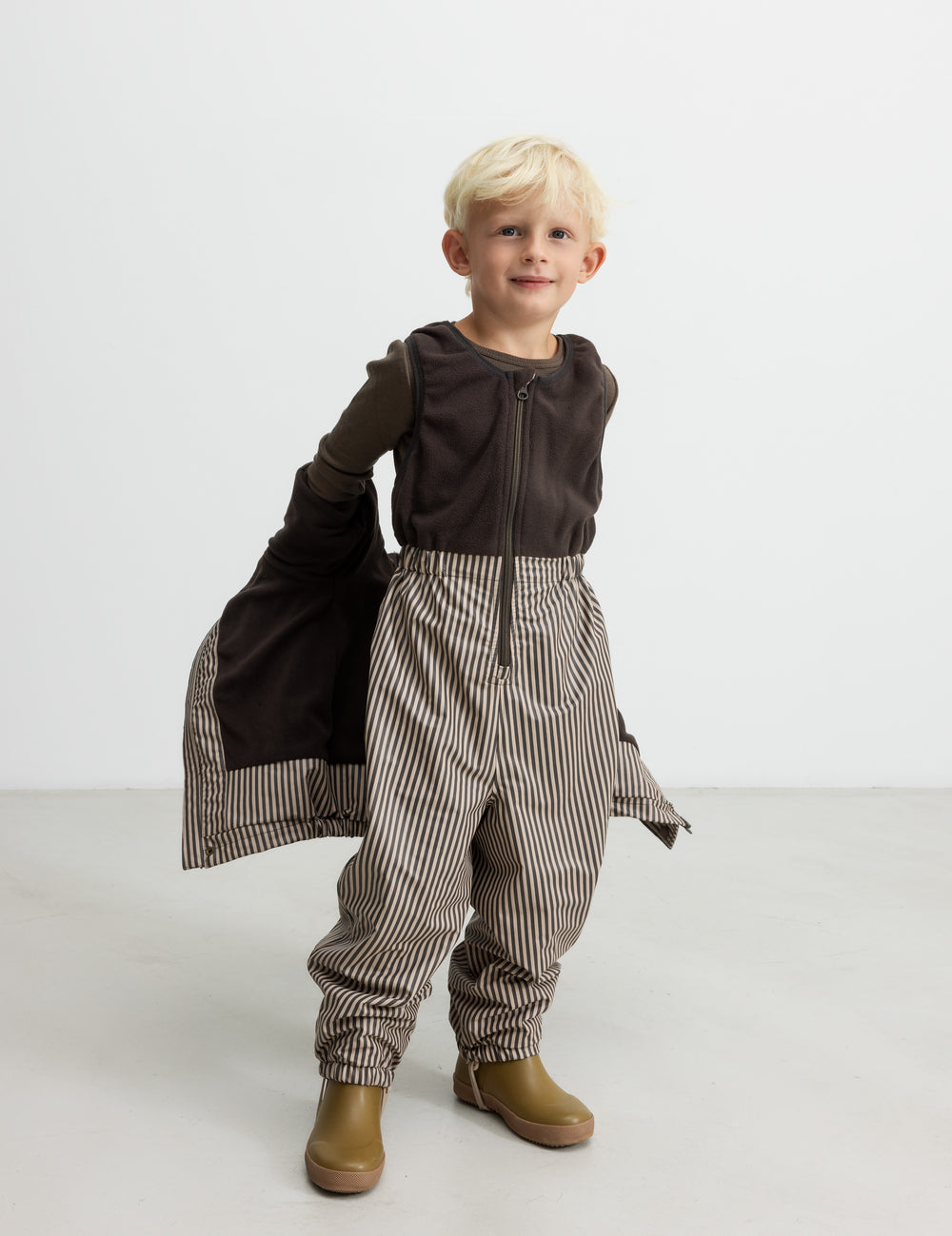 Børn iført brune stribede selebukser og brun trøje