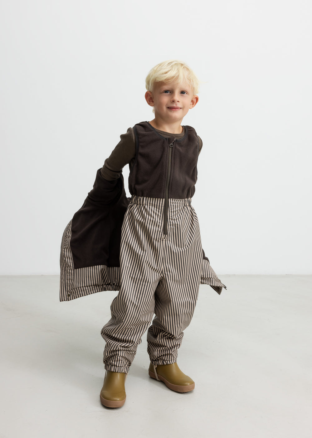 Børn iført brune stribede selebukser og brun trøje
