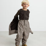 Børn iført brune stribede selebukser og brun trøje