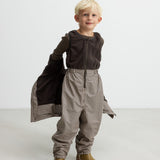 Børn iført brune stribede selebukser og brun trøje