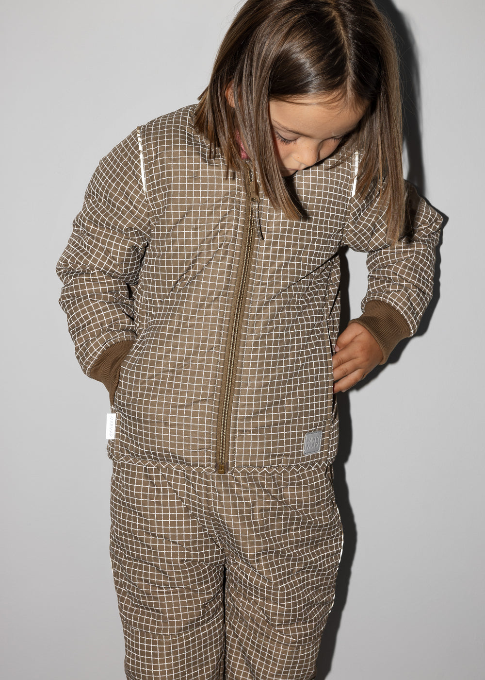 Barn iført ternet termojakke og matchende termobukser