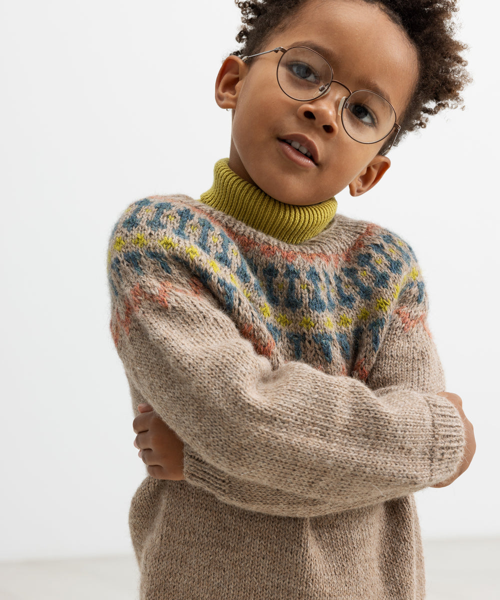 Børn i beige uldstrikbluse med farvet bærestykke