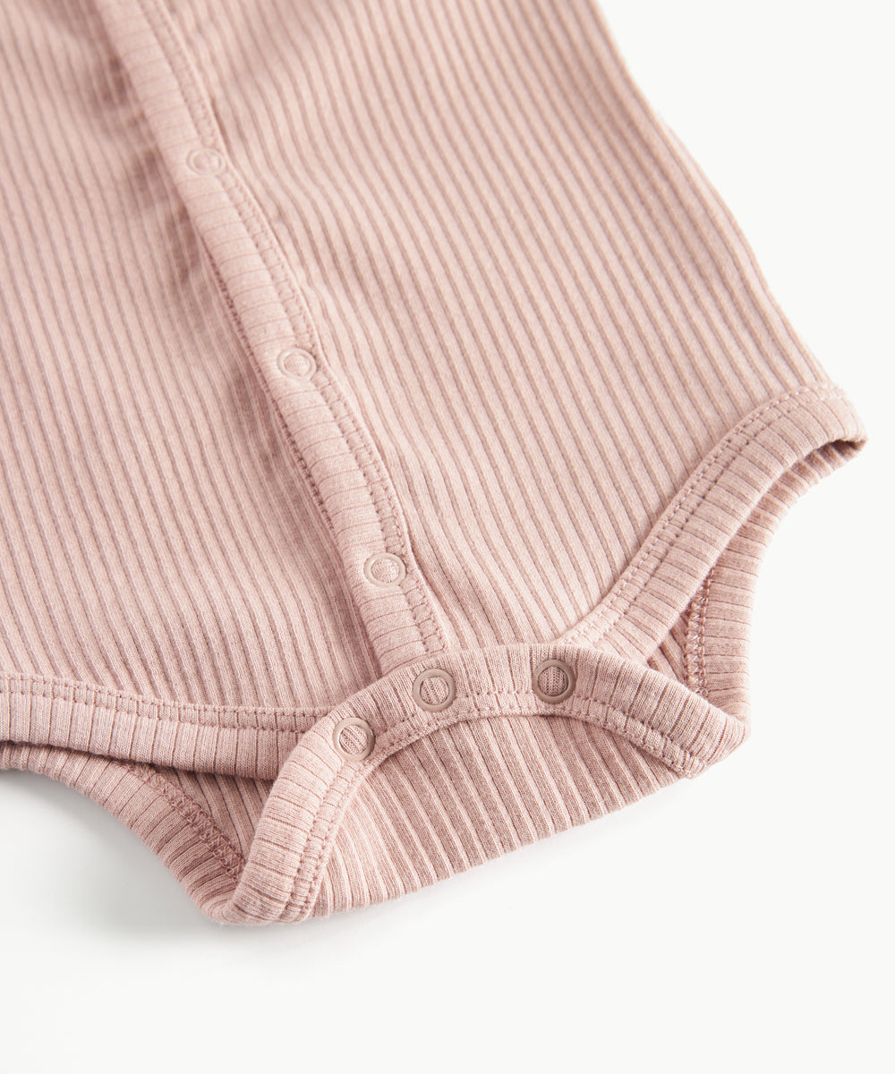 Lyserød ribstrikket babybody med knapper foran
