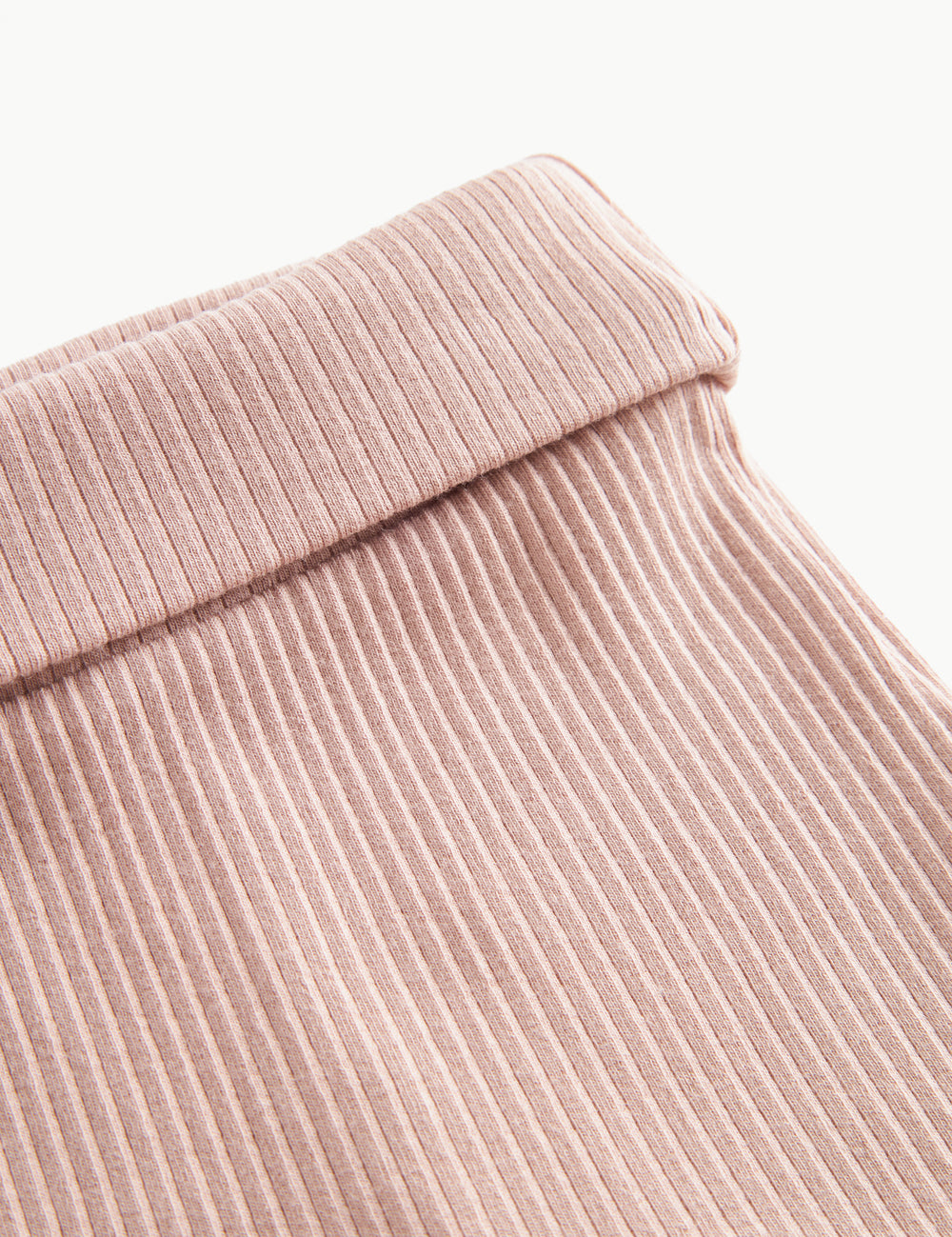 Nærbillede af ribstrikket elastisk talje på lyserøde leggings med fod til baby