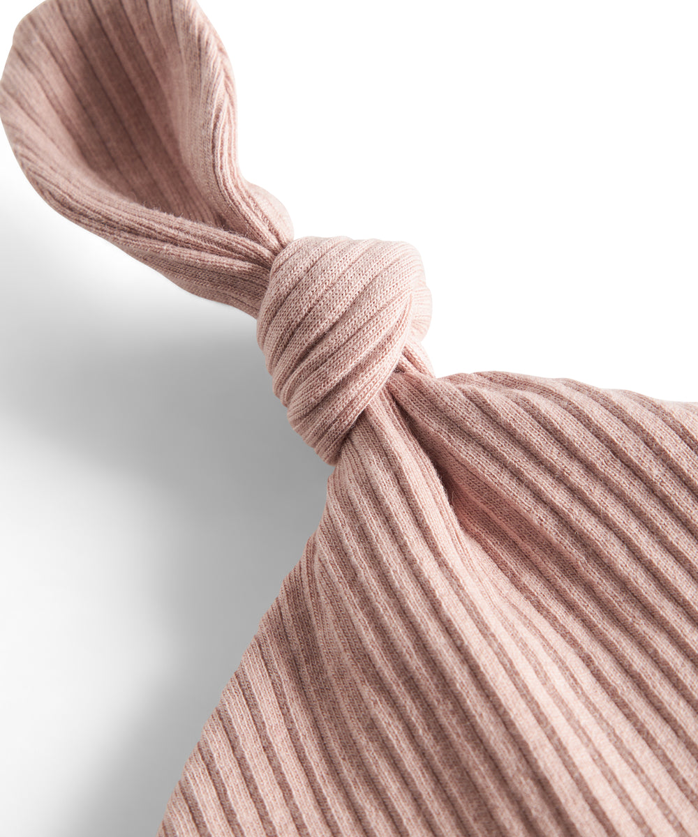 Lyserød ribstrikket babyhue med knude på toppen og opbukket kant