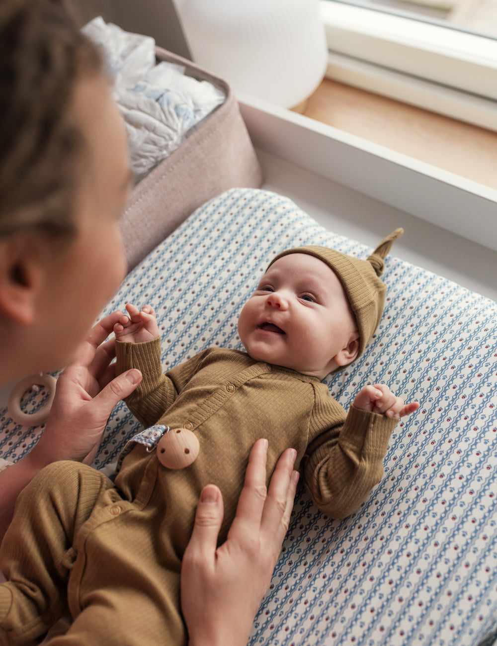 Baby i ribbstrikket brun holdragt til baby i blødt materiale med lange ærmer, lange ben, tryknapper og futter og brun babyhue