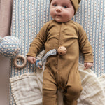 Baby iført brun ribstrikket hue og heldragt