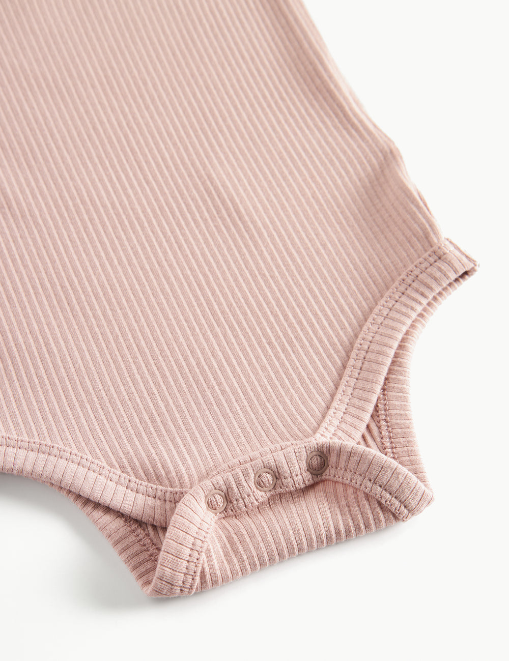 Lyserød ribstrikket babybody med lange ærmer, stolpe knaplukning og trykknapper mellem benene