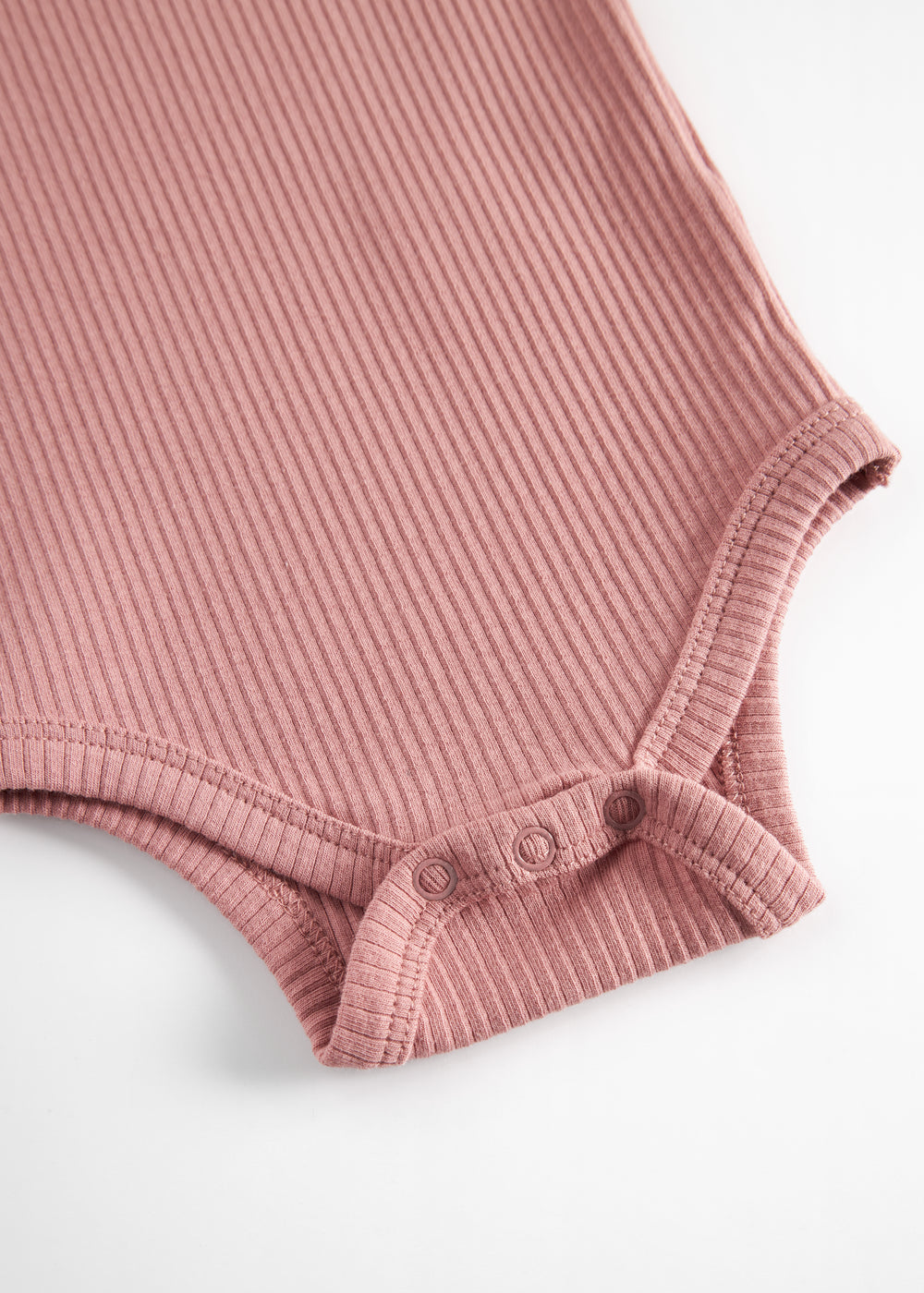 Lyserød ribstrikket babybody med lange ærmer og knapper