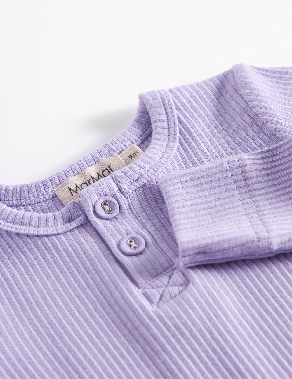 Lilla ribbstram babybody med lange langeermer, stolpe knappning og trykknapper mellem benene.