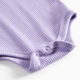 Lilla ribstrikket babybody med lange ærmer, stolpe knaplukning og trykknapper mellem benene