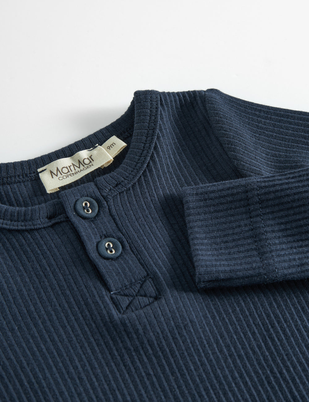 Blå strikket babybody med lange ærmer, stolpe knaplukning og trykknapper mellem benene