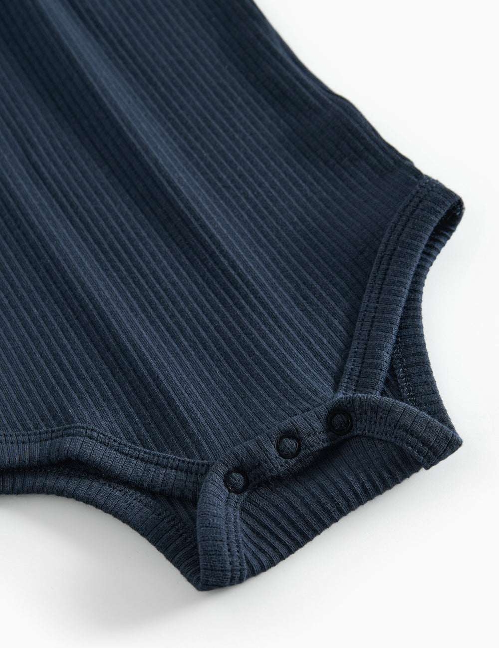 Blå ribstrikket babybody med lange ærmer, stolpe knaplukning og trykknapper mellem benene