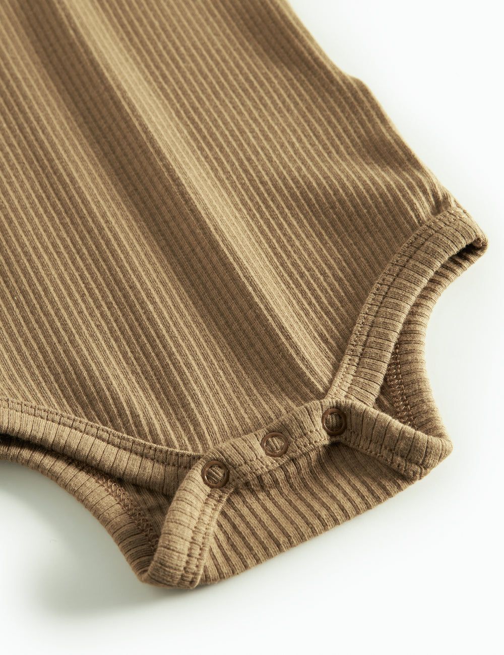 Brun strikket babybody med lange ærmer, stolpe knaplukning og trykknapper mellem benene.