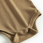 Brun ribstrikket babybody med lange ærmer, stolpe knaplukning og trykknapper mellem benene