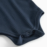 Blå ribstrikket babybody med lange ærmer og knapper mellem benene